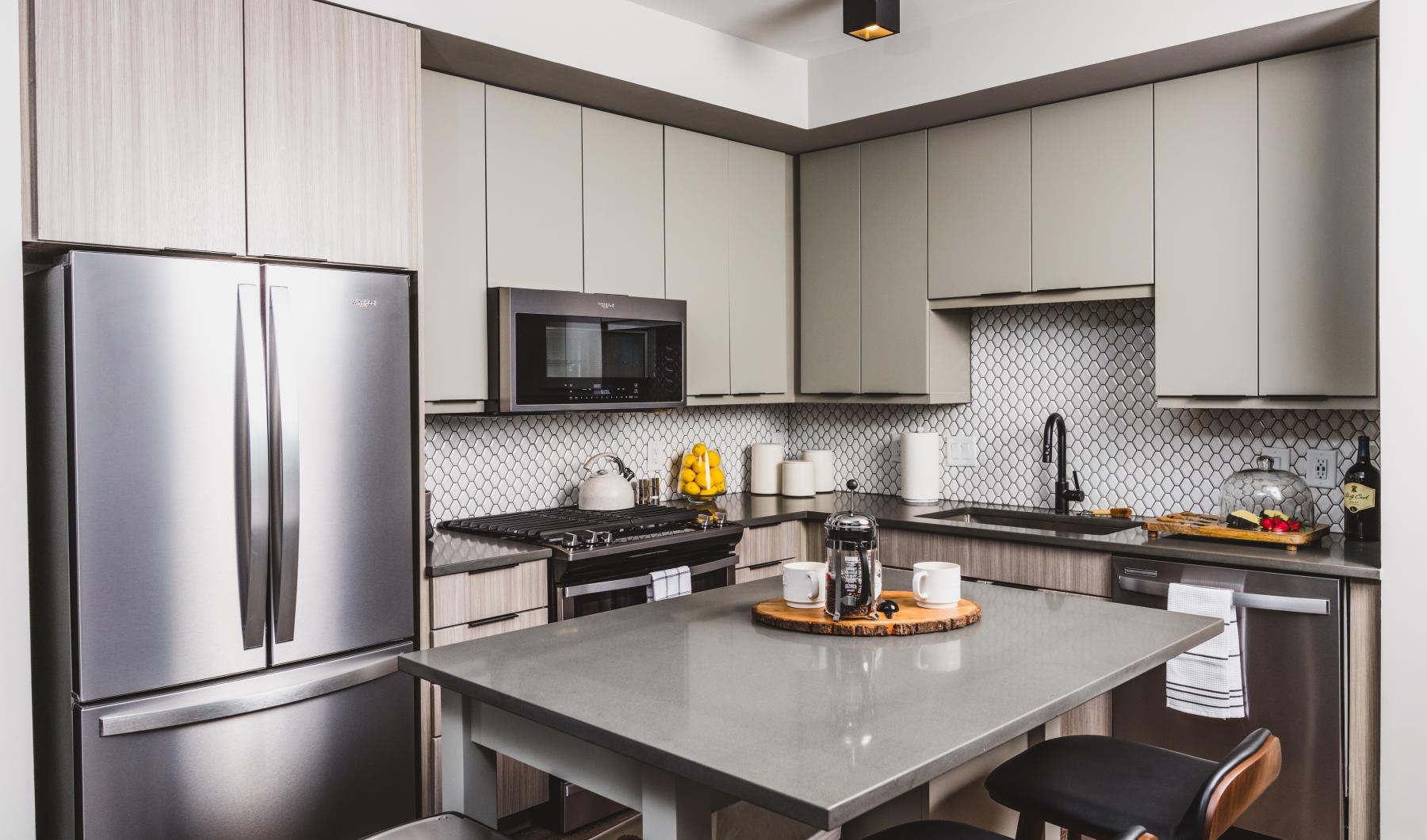 Beautiful kitchens with designer finishes a kitchen with a table and refrigerator