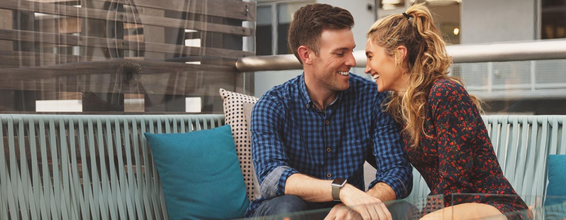 a man and woman sitting at a table and a fire pit